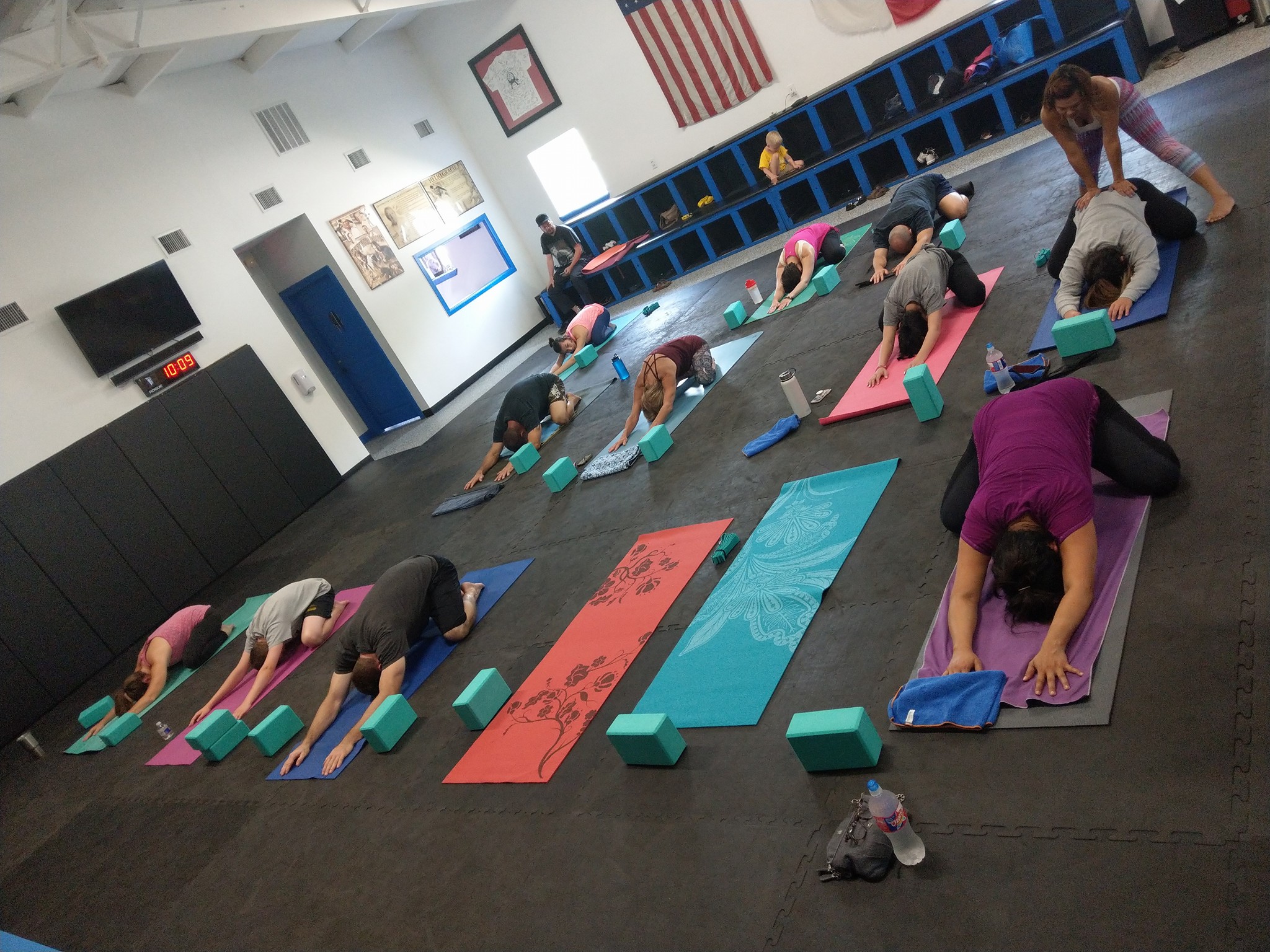 Yoga participants stretching out on mats in the gym
